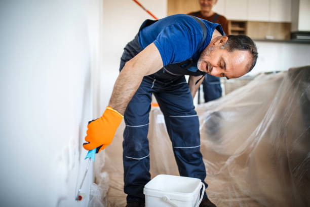 istock Senior man painting apartment interior 1213345504