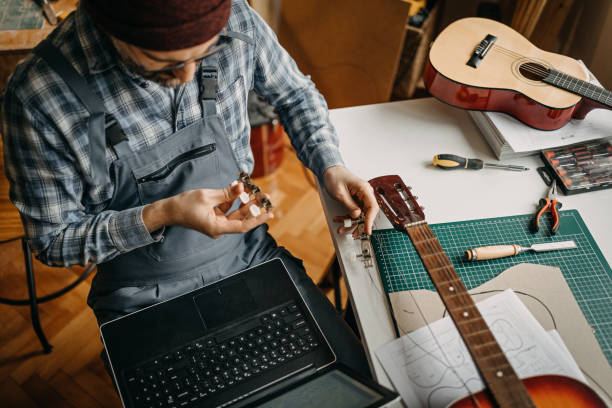 istock Man repairing guitar in home workshop 1213349059