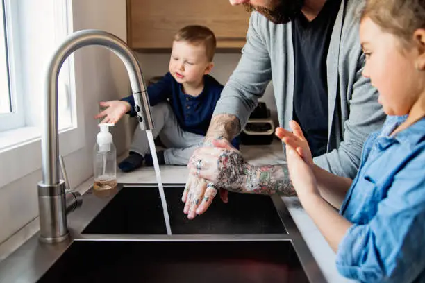 Photo of Father teaching young children how to wash their hands in quarantine isolation Covid-19