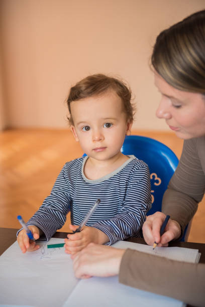 istock Toddler learning how to draw and write with his mother 1213351186