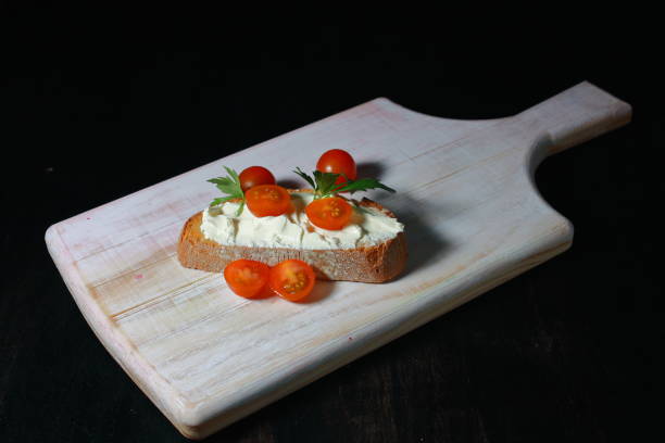 toast au fromage frais avec de petites tomates raisins et une feuille de persil - tostada photos et images de collection