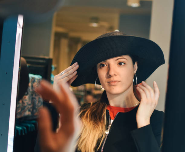 istock Smiling female try on the new hat look at mirror reflection 1213353201