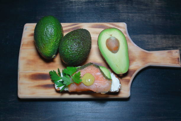 tostada de salmon ahumado sobre un lecho de aguacate y queso freso, con un toque de pimienta negra y perejil - tuna salad sandwich fotografías e imágenes de stock