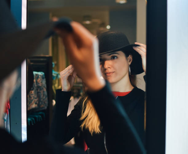 istock Smiling female try on the new hat look at mirror reflection 1213354991