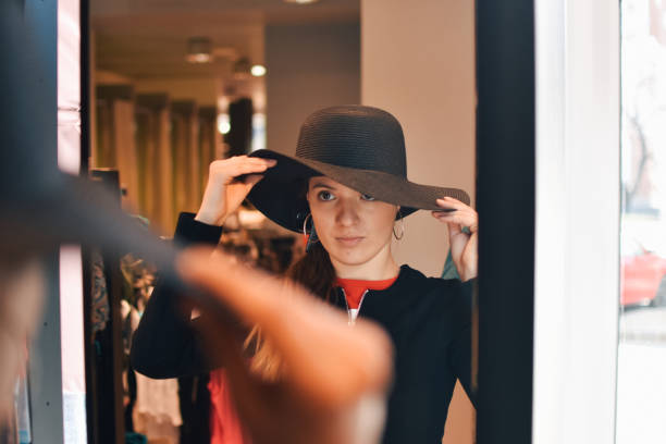 istock Smiling female try on the new hat look at mirror reflection 1213355094