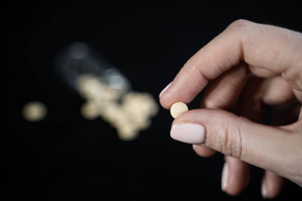 Woman hand holds antiviral pill in fingers. Drug researched in laboratory speeds up coronavirus recovery in early trials of COVID-19. Active against virus SARS-CoV-2. Used in ebola disease curation la mano de la mujer sostiene la píldora antiviral en los dedos. el fármaco investigado en laboratorio acelera la recuperación del coronavirus en los primeros ensayos de covid-19. activo contra el virus sars-cov-2. utilizado en la curación de la enferme