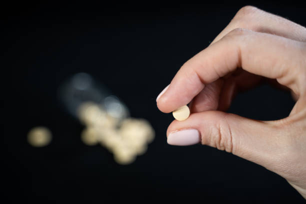 Woman hand holds antiviral pill in fingers. Drug researched in laboratory speeds up coronavirus recovery in early trials of COVID-19. Active against virus SARS-CoV-2. Used in ebola disease curation la mano de la mujer sostiene la píldora antiviral en los dedos. el fármaco investigado en laboratorio acelera la recuperación del coronavirus en los primeros ensayos de covid-19. activo contra el virus sars-cov-2. utilizado en la curación de la enferme