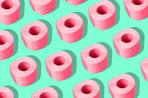 Papel higiénico sobre un fondo de color. Un rollo repetitiva de papel rosa. Arte contemporáneo, minimalismo. photo