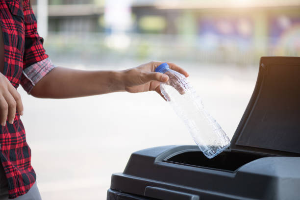 istock Closeup portrait woman hand throwing empty plastic water bottle in recycling bin. 1213362072