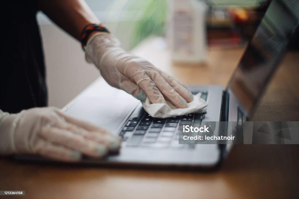 Menschliche Hände reinigen die Laptop-Oberfläche gegen Viren - Lizenzfrei Das Leben zu Hause Stock-Foto