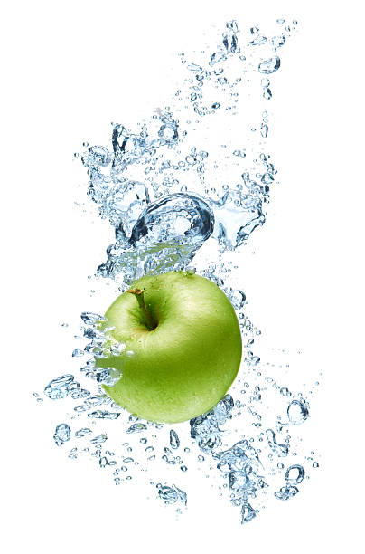istock Green apple amidst a splash of water isolated in white 121336689