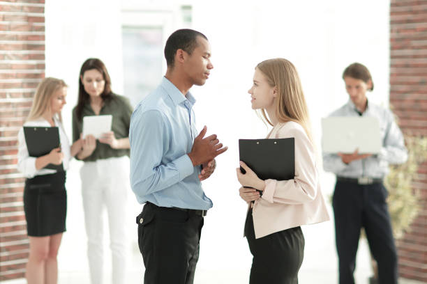 istock employees discussing business document standing in the office 1213369888