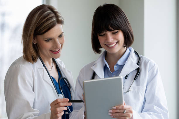 istock Two women doctors looking at digital tablet together 1213372629