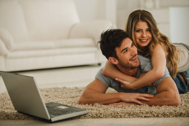 istock Cheerful couple having a cuddle while lying on the floor 1213374262