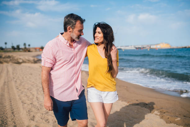 istock Happy couple enjoying on the beach 1213374927