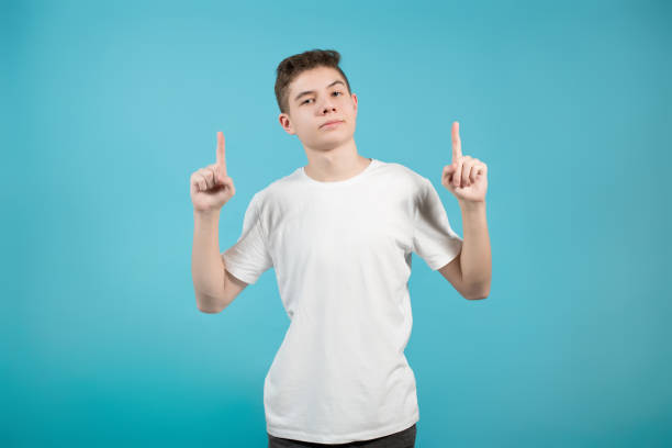 istock young man in white t-shirt points his index fingers up 1213374979