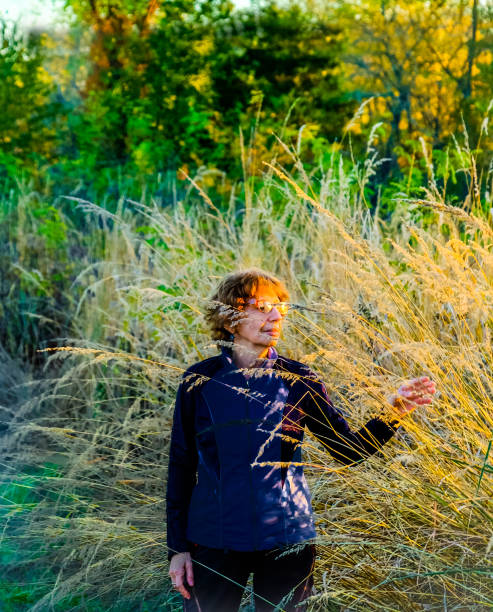 istock Senior woman in tall grass at sunset 1213376609