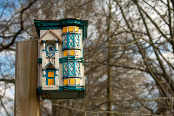 A Detailed Teal and White Bird House in a Dead Forest