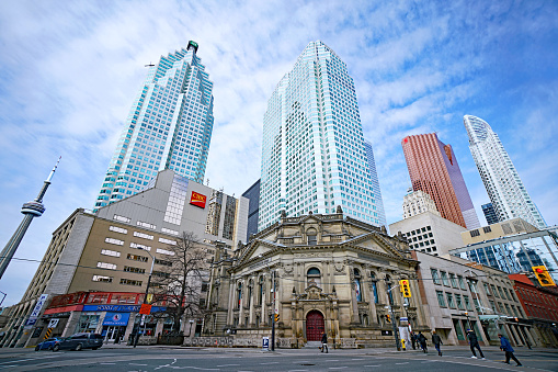 Toronto, Canada - March 18, 2020:  The Hockey Hall of Fame is housed in an ornate Victorian bank building, surrounded by modern skyscrapers.