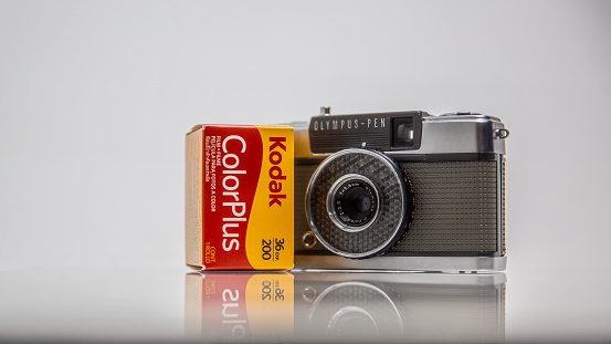 Picture of  vintage analog film model CoLorPlus 36 exp. 200, 35 mm, in a box, brand new and Olympus PEN-EE camera, Manually camera with half-frame technic, Kodak and Olympus Company logo , Illustrative Editorial Image