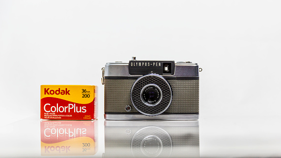 Picture of  vintage analog film model CoLorPlus 36 exp. 200, 35 mm, in a box, brand new and Olympus PEN-EE camera, Manually camera with half-frame technic, Kodak and Olympus Company logo , Illustrative Editorial Image