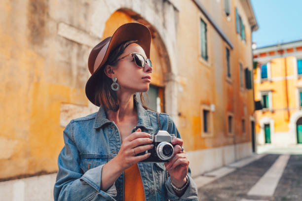istock Attractive tourist with a retro camera 1213397558