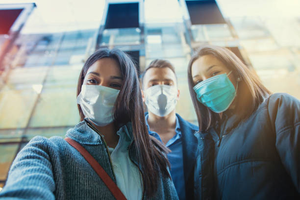 Group of people wearing mask taking selfie outside. Close-up stock photo