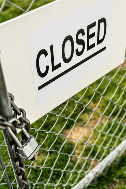 istock A CLOSED sign on and chainlink fence gate that is locked with a padlock 1213398476