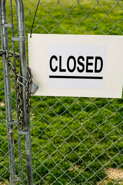 istock A CLOSED sign on and chainlink fence gate that is locked with a padlock 1213399009