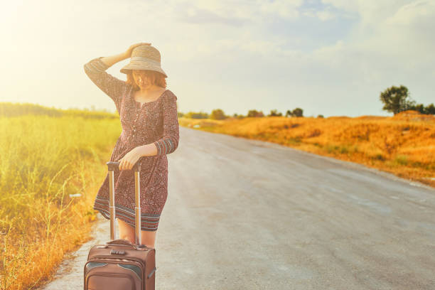 istock Woman with suitcase on the road 1213399177