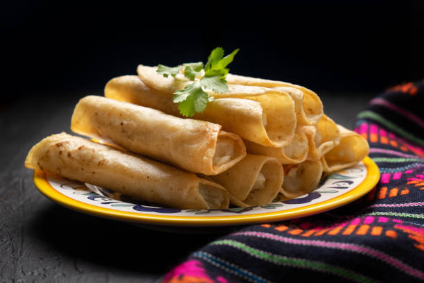 istock Mexican potato and cheese fried tacos also called flautas on dark background 1213399253