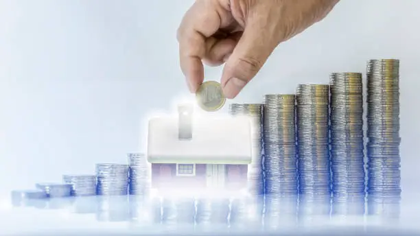 Double exposure image of money stacking as big growth of profit or successful of house construction cost management, business and financial concept.