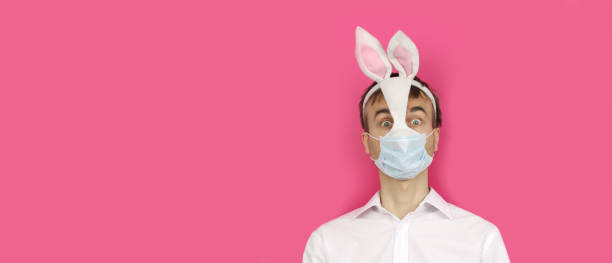 баннер с испуганным человеком в маске пасхальный кролик и медицинская маска смотреть вперед, вирус или коронавирус защиты и профилактики п - pasch стоковые фото и изображения