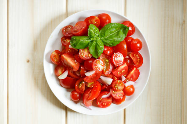 istock red cherry tomato and basil leaf on white plate on wooden background 1213414829