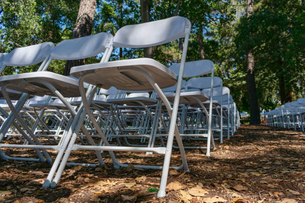 istock White folding plastic chairs set up an outdoor in a row 1213418637