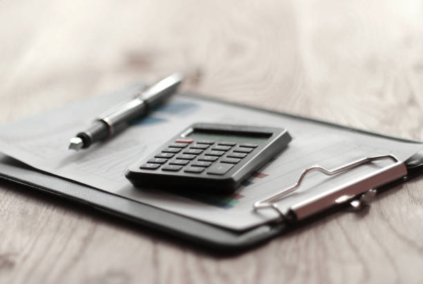 istock close up. blurred image of pen and calculator on desktop 1213422097