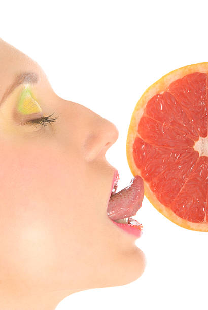 istock Woman with make-up licks grapefruit 121342789
