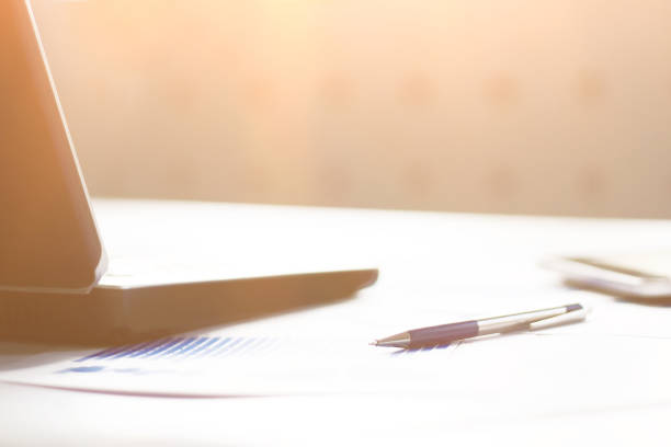 istock business background: laptop,financial chart and pen on office workplace 1213428519