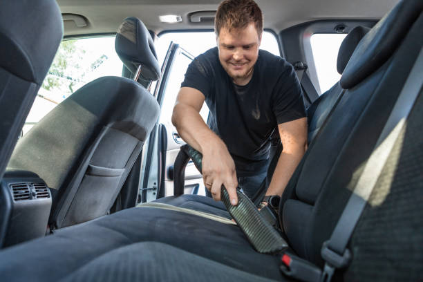 istock man cleaning inside car with vacuum cleaner seats 1213428539
