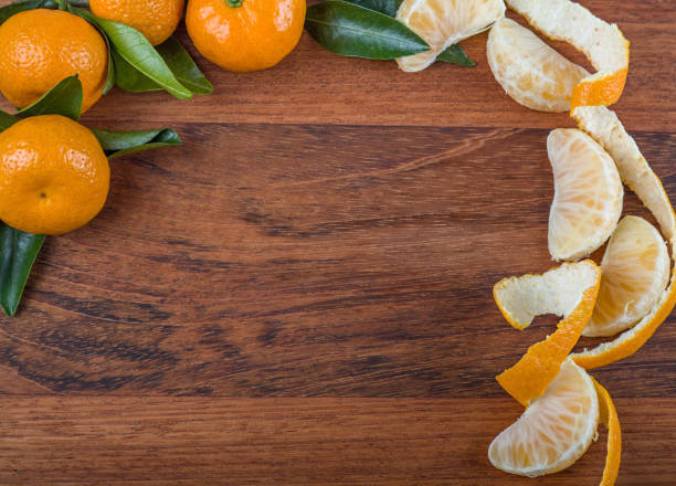 istock ripe tangerines frame on dark brown background 1213430417