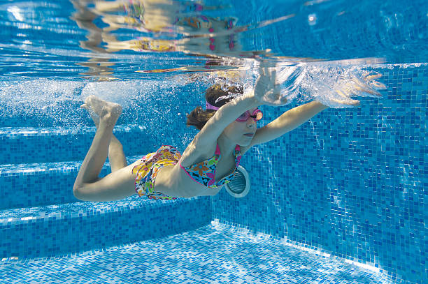 istock Child swimming underwater in pool 121343240