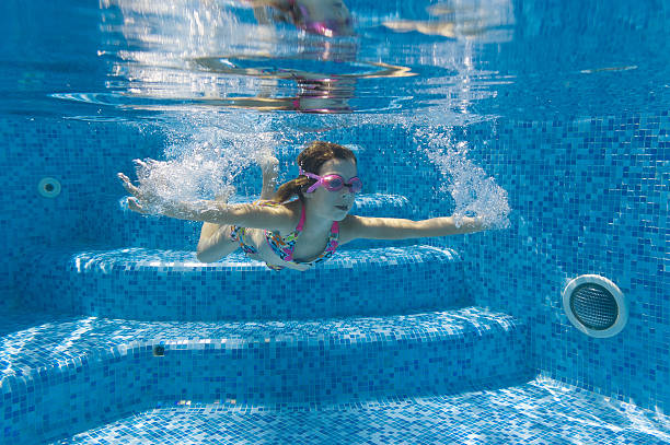 istock Child swimming underwater in pool 121343242