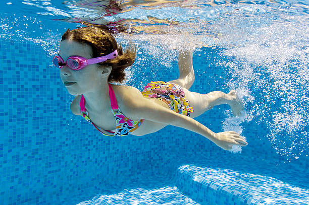 istock Child swimming underwater in pool 121343245