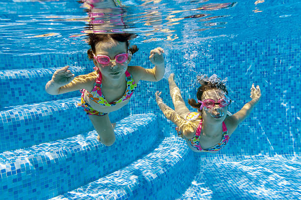 istock Children swimming underwater in pool 121343252