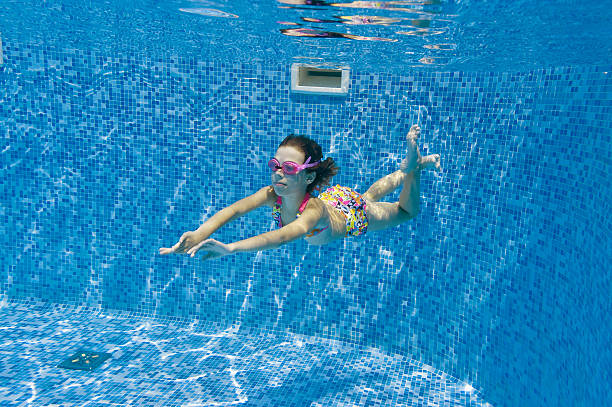 istock Child swimming underwater in pool 121343256