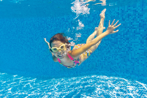 Happy smiling underwater kid in swimming pool