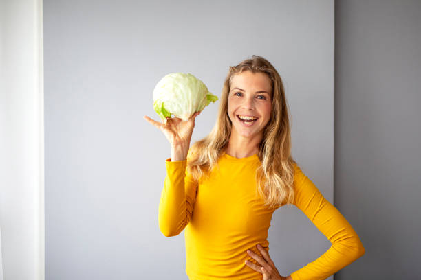 istock Woman with cabbage on her hand in kitchen 1213432795