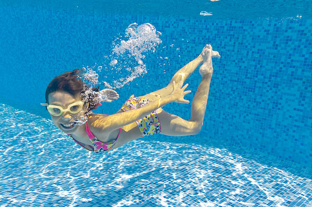 istock Smiling child swimming underwater in pool 121343305