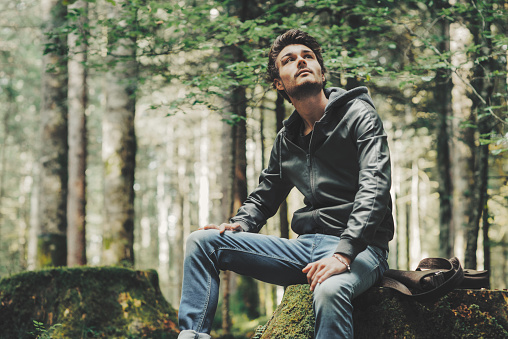 Young man exploring a forest and relaxing in nature
