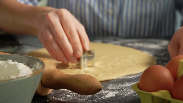 hands cutting dough with star shaped cutter